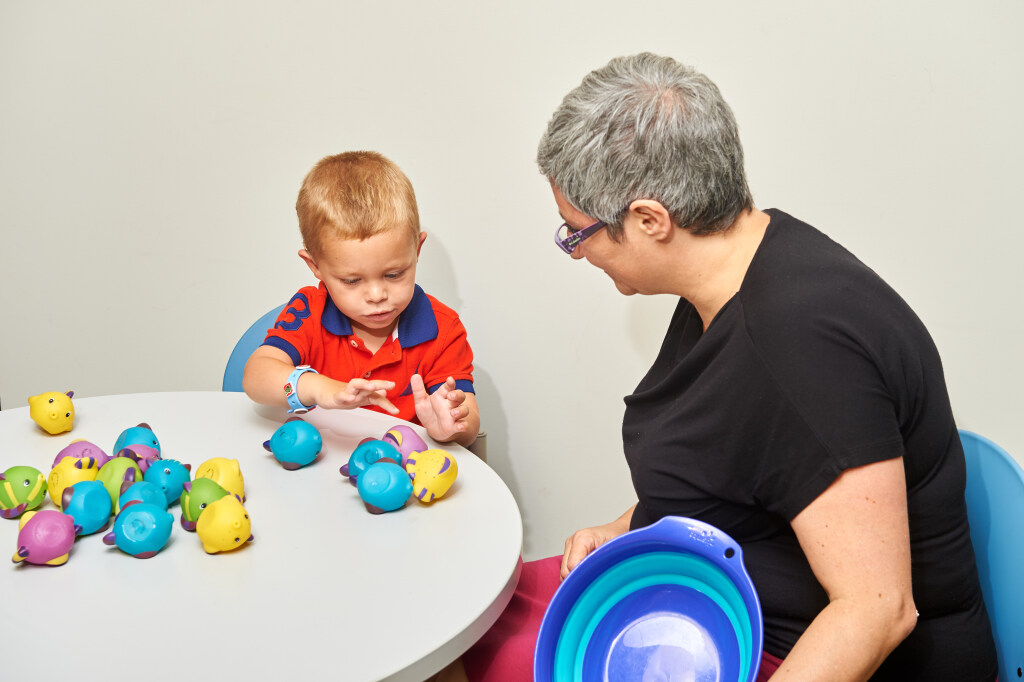 A faculty member works with a child participant in their lab.