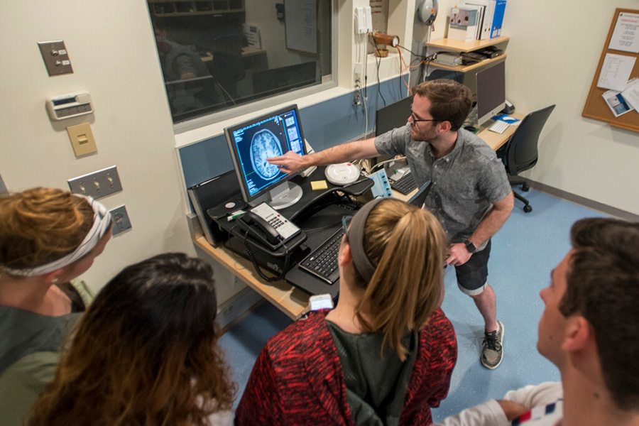 An instructor in the Brain Imaging Research Center discusses a brain scan with students.